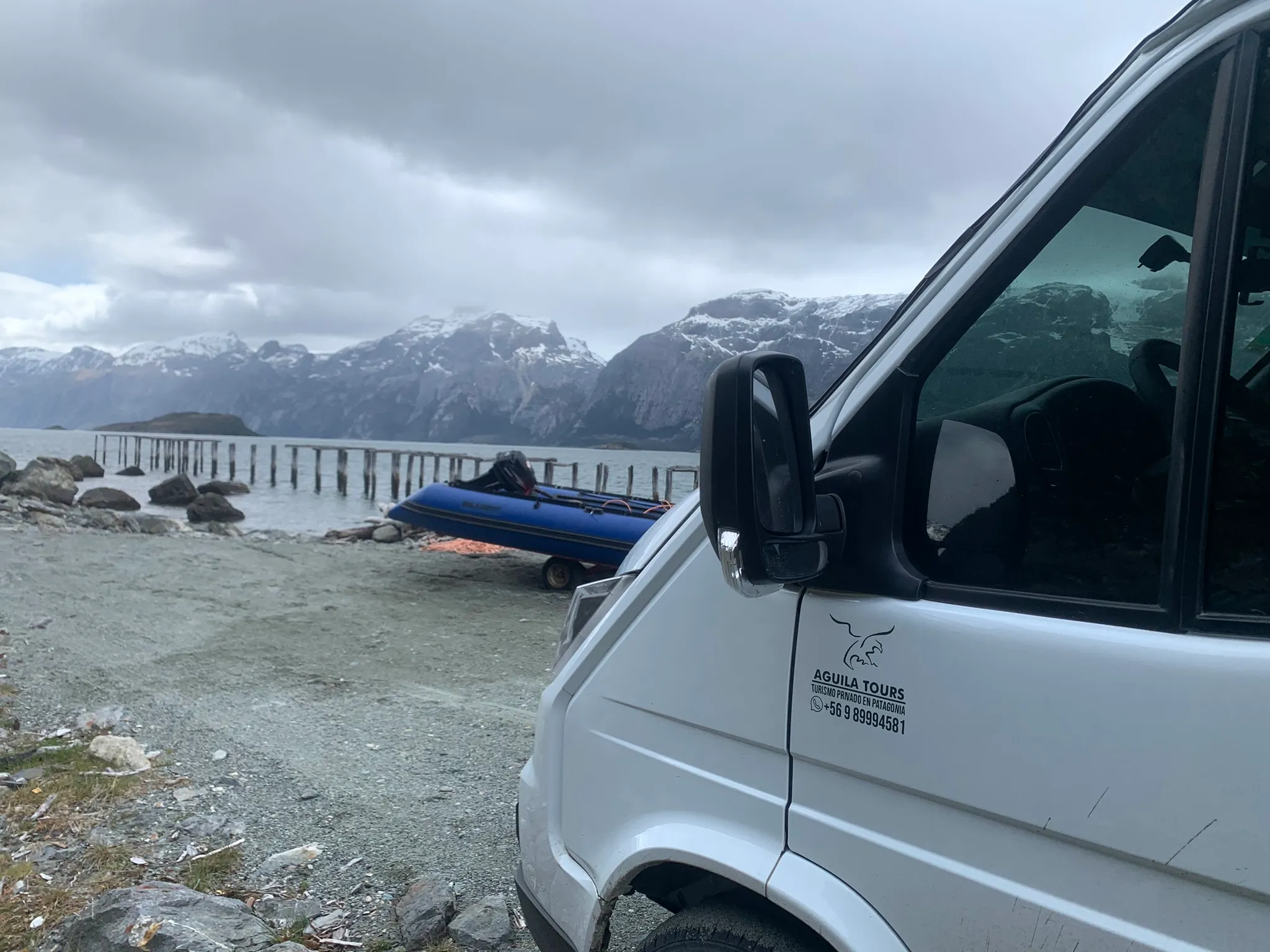 Minibús de Aguila Tours estacionado frente a los Cuernos del Paine